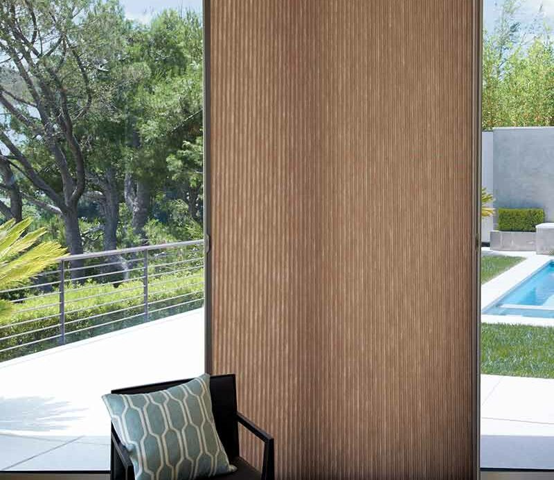 brown vertical honeycomb shades open to reveal pool