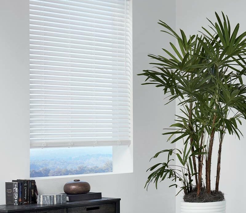 white faux blinds open slightly to see the outdoors