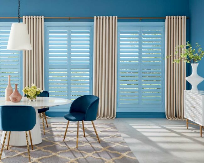 blue wooden shutter painted a pale blue in modern dining room space with drapery