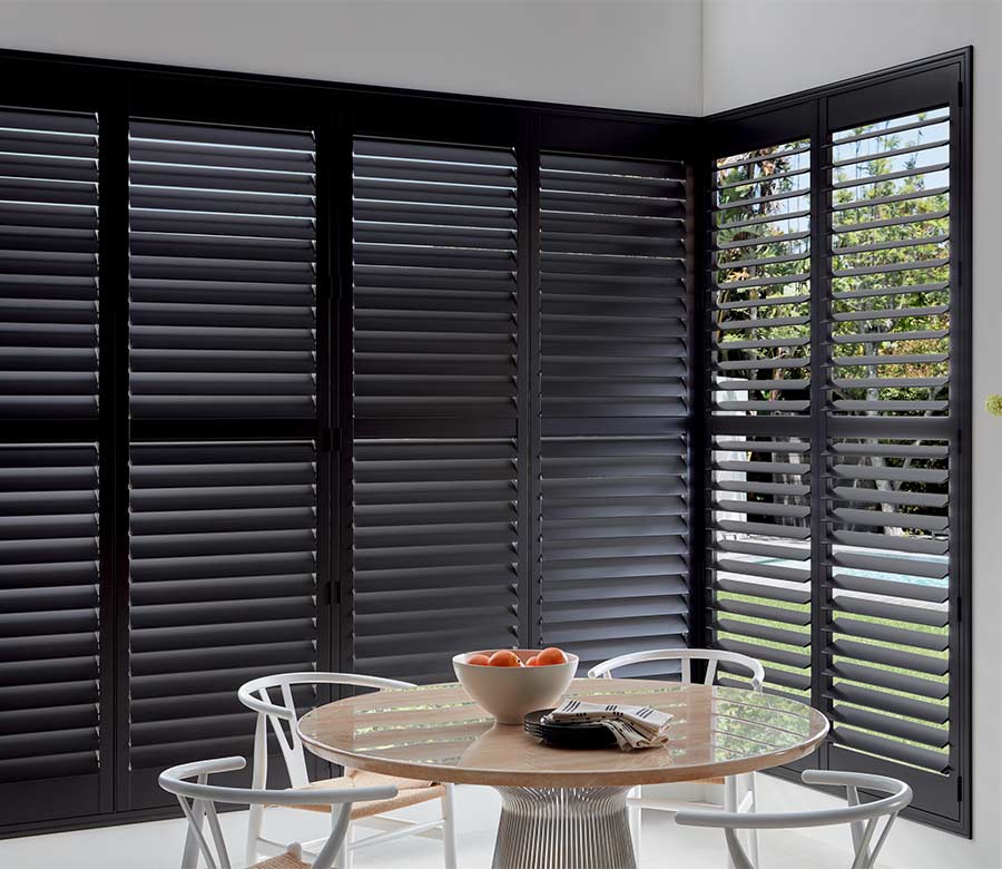 breakfast nook with black shutters floor to ceiling showing outdoors