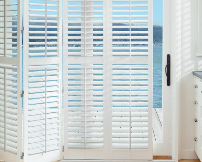 bi-fold white shutters opening to view of the lake