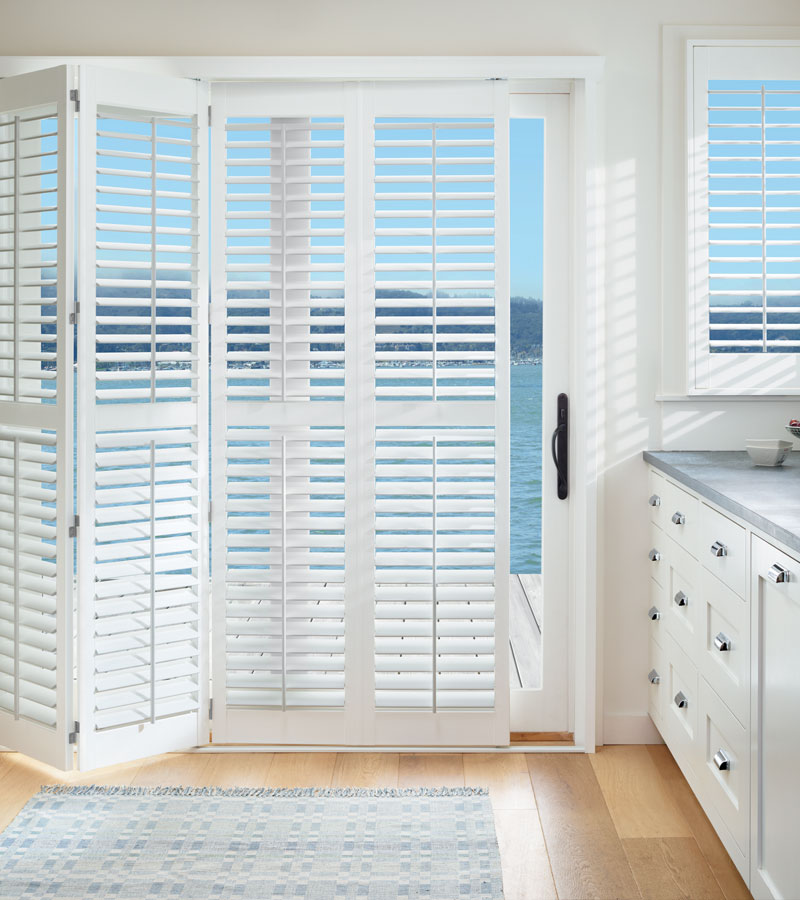 bifold white shutters on sliding door leading to outdoors