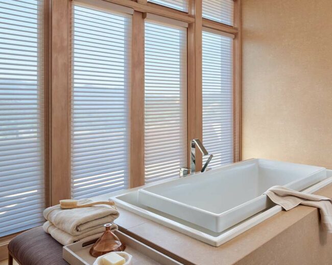 master bathroom sunken tub next to privacy shades framed with warm wood