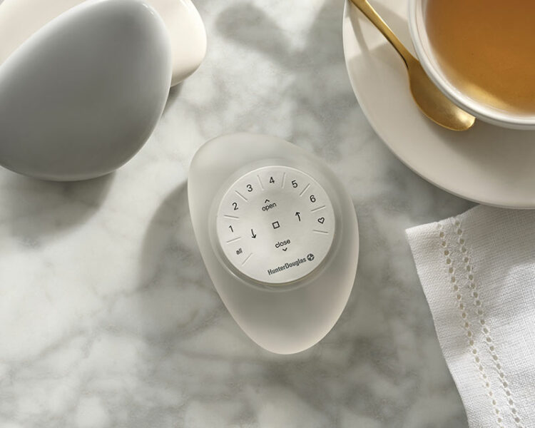 clear pebble remote on marble table next to herbal tea in teacup