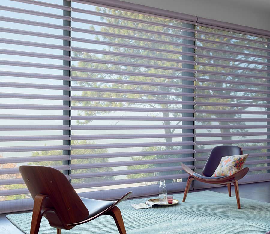 large windows with purple shades next to mid century modern chairs