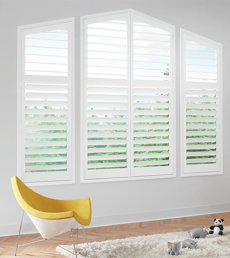 angled tri-windows with white hybrid shutters for durability light control from Hunter Douglas Shutters