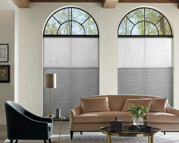 living room design with arched windows with black trim, covered by honeycomb shades in Omaha