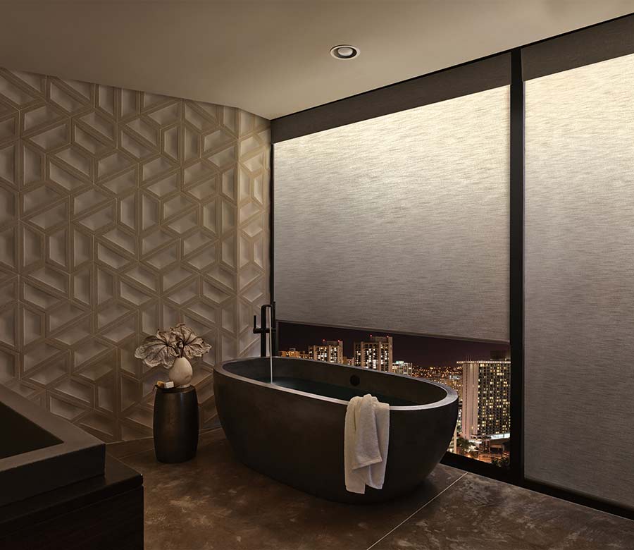 a modern bathroom with a tub next to large windows covered by illuminated privacy shades with warm light