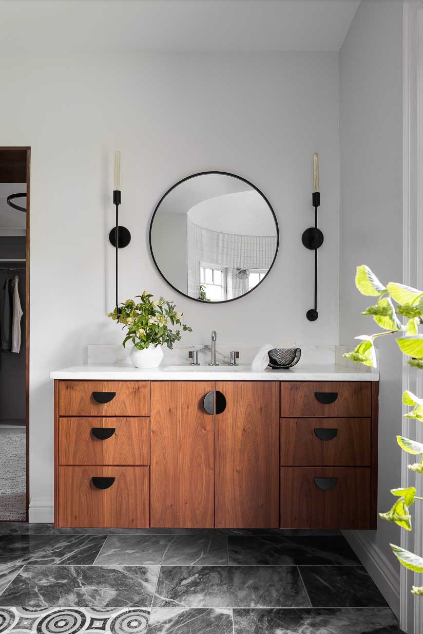 bathroom with updated circle mirror and wood detail