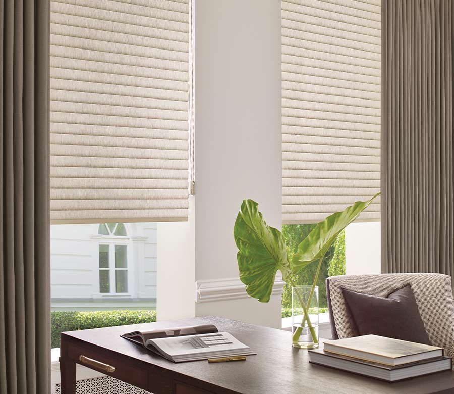 pinch pleat curtains in home office with cellular roller shades