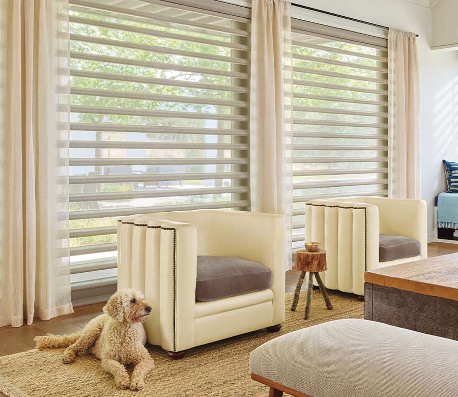 living room with sheer drapes on black drapery rod layered over window shades